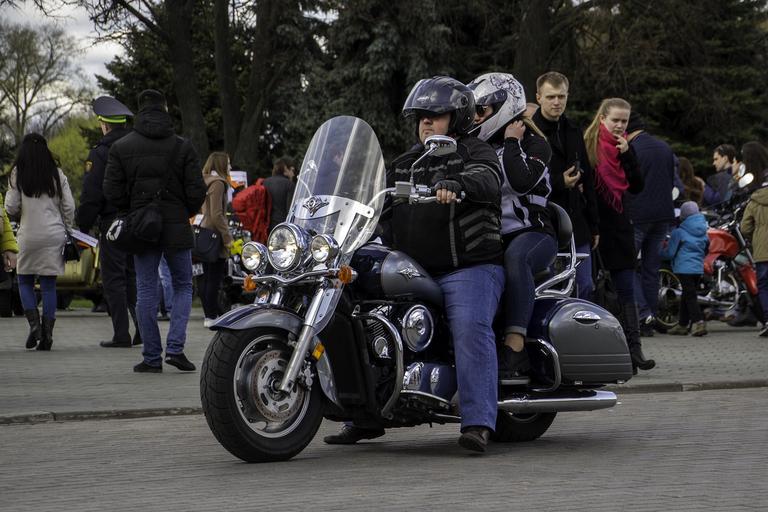 Muž so ženou sedia na motorke, motorkári